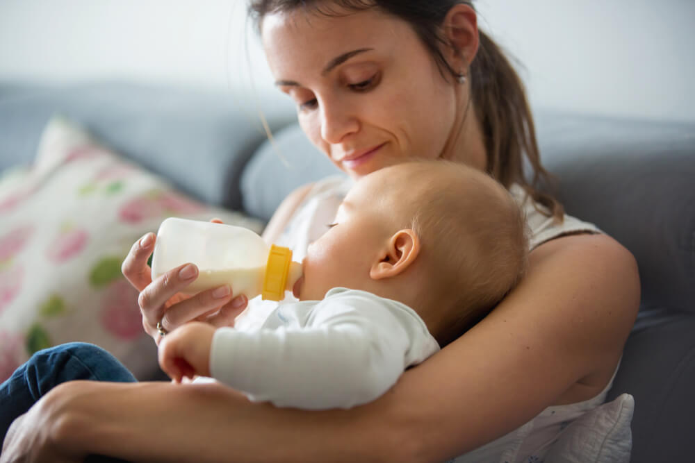 Madre alimentando a su bebé con un biberón