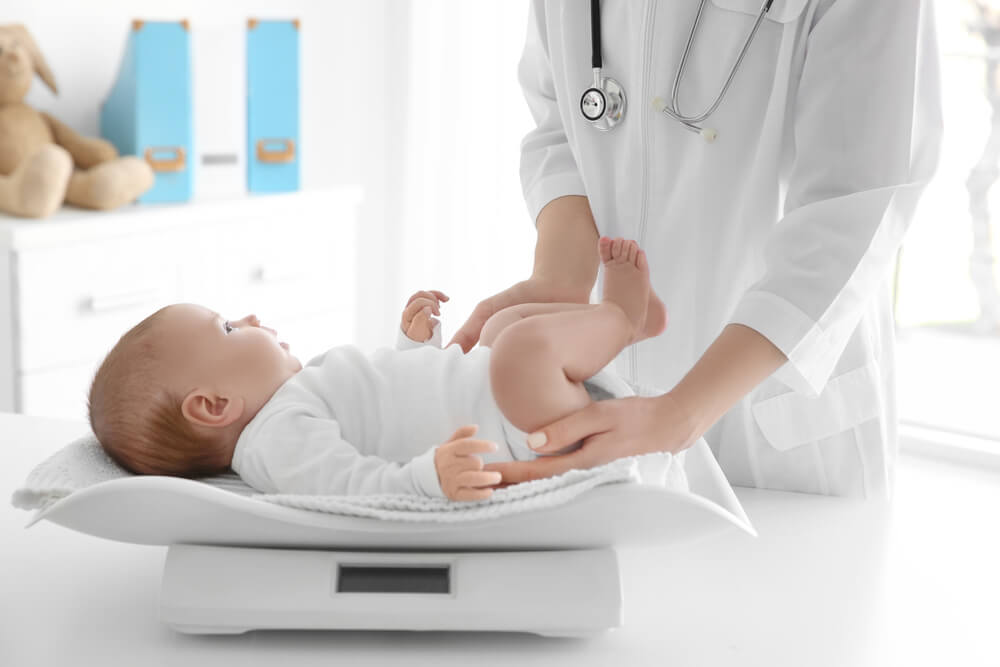 Pediatra pesando bebé