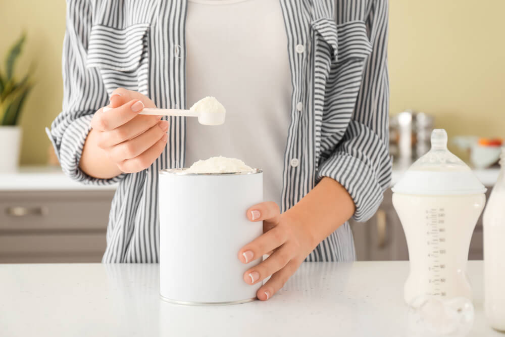 Mujer preparando biberón con leche de fórmula