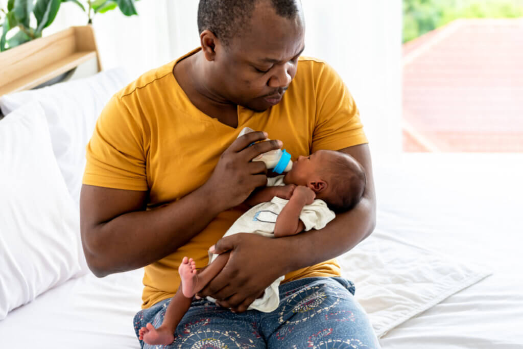Padre alimentanto bebé con biberón