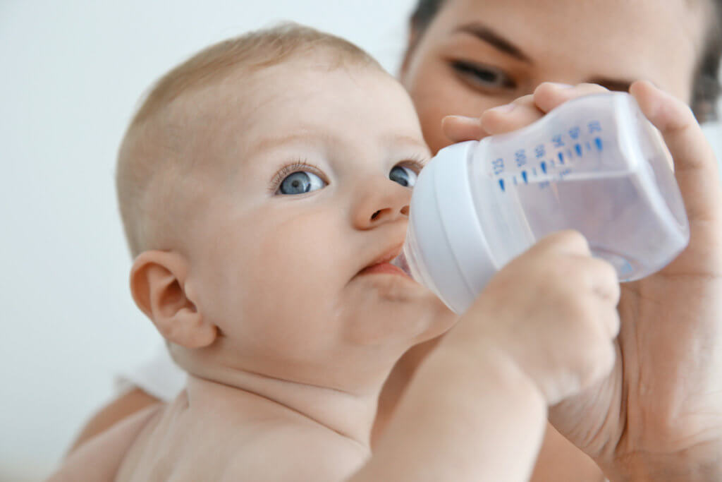 Mamá ofreciendo agua a su bebé