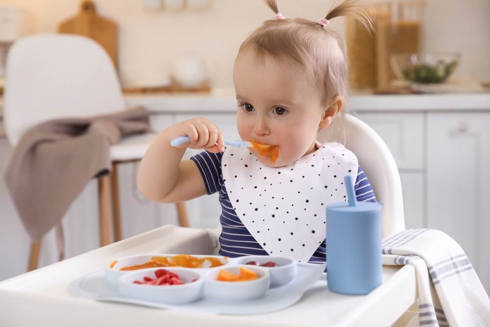 Bebé comiendo sola con cuchara