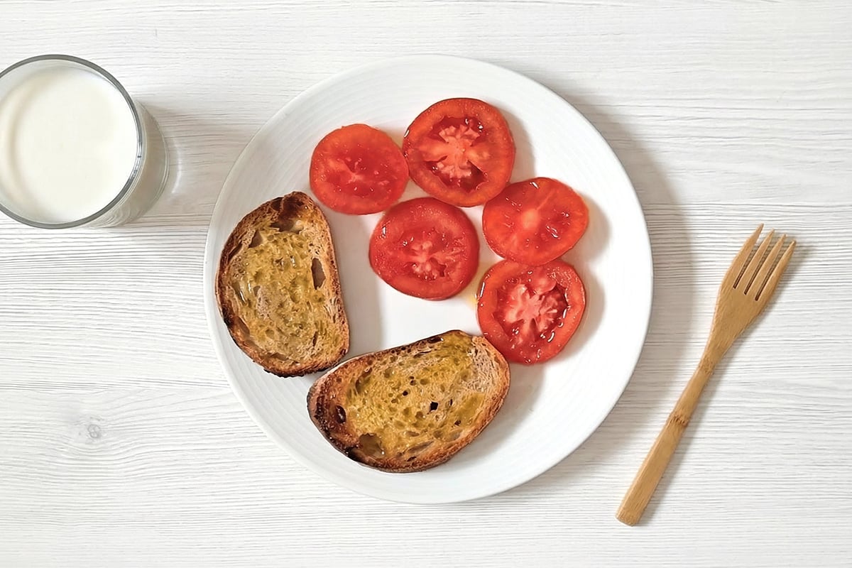 Desayuno para niños: leche, tostadas con aceite y tomate
