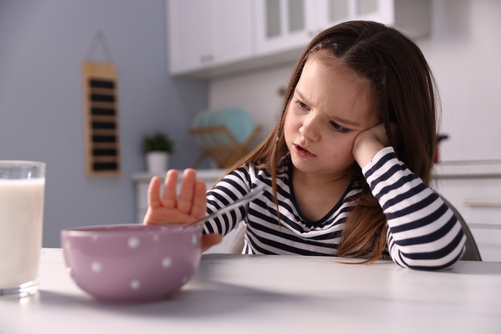 Niña rechaza cuenco de cereales con leche